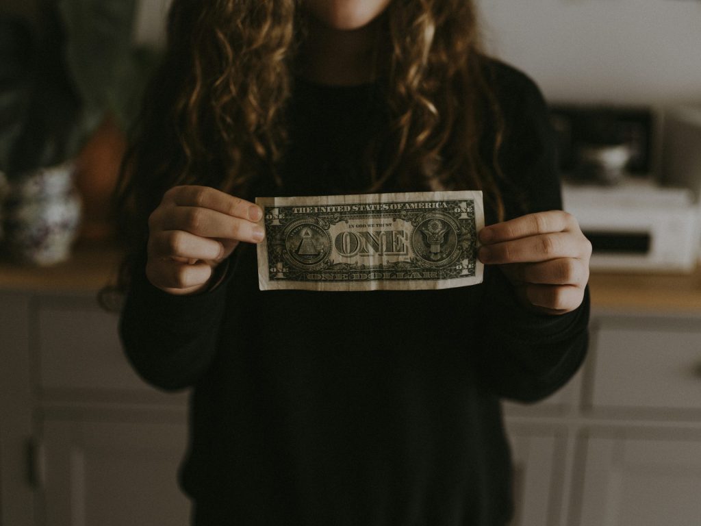 Person showing a single dollar bill