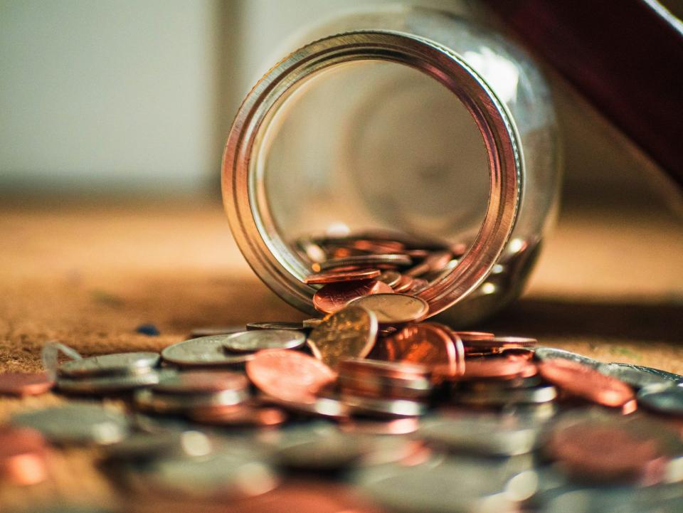 Coins falling from jar onto table