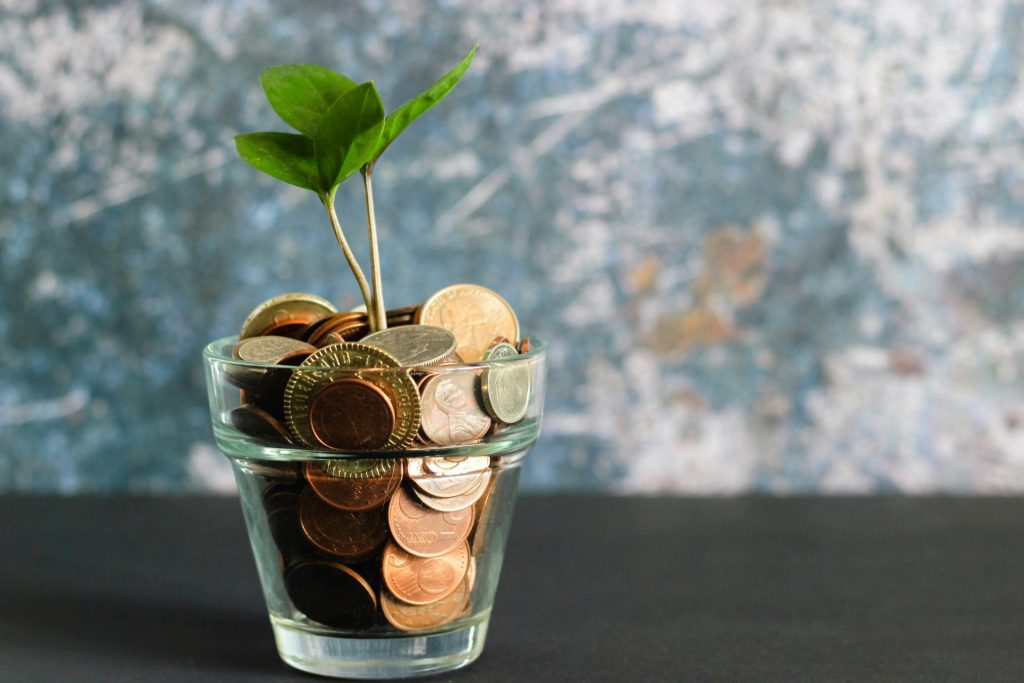 Glass jar filled with coins spilling out.